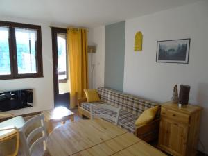 salon z kanapą i stołem w obiekcie Appartement au cœur du village avec parking privé w mieście Mijoux