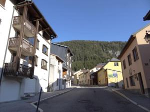 pusta ulica w małym miasteczku z budynkami w obiekcie Appartement au cœur du village avec parking privé w mieście Mijoux
