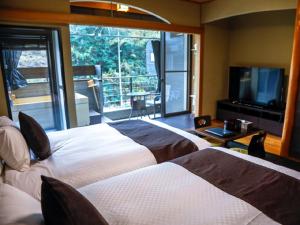 松山的住宿－LiVEMAX RESORT Okudogo，酒店客房设有两张床和大窗户。