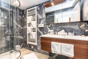 ein Bad mit einem Waschbecken und einer Dusche in der Unterkunft Gasthof Andrelwirt Rauris in Rauris