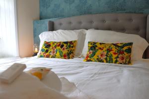 uma cama com lençóis brancos e almofadas com cabeceira em The Little Lion Inn, Red Lion em Wellingore