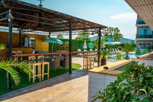 an outdoor patio with a bar and tables and chairs at Gradina Holiday in Sozopol