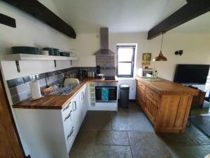 een keuken met een spoelbak en een aanrechtblad bij Bonneys Barn Retreat - Luxury homely getaway in Burgh Saint Peter +27 foto's