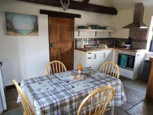een keuken met een tafel en stoelen met een tafel bij Bonneys Barn Retreat - Luxury homely getaway in Burgh Saint Peter