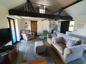 een woonkamer met een bank en een trap bij Bonneys Barn Retreat - Luxury homely getaway in Burgh Saint Peter