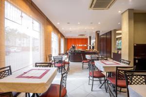a restaurant with tables and chairs and a counter at Hotel Plaza Norte in Joinville