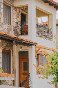 - un bâtiment avec balcon et porte en bois dans l'établissement Paliouri holidays maisonette, à Paliouri