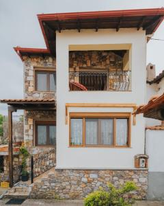 une maison blanche avec un mur en pierre dans l'établissement Paliouri holidays maisonette, à Paliouri