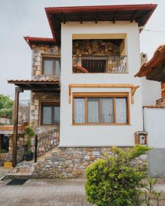 une maison blanche avec une façade en pierre dans l'établissement Paliouri holidays maisonette, à Paliouri