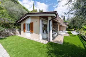 a small house with a green lawn in front of it at Ferienwohnung Casa 50 in Gargnano