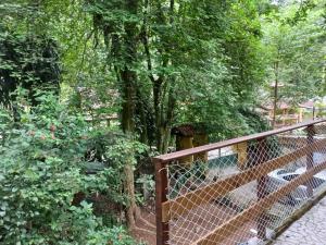 una valla de madera junto a un jardín con árboles en Loft dos Vagalumes en Boicucanga