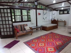 - un salon avec un canapé et un tapis dans l'établissement Loft dos Vagalumes, à Boicucanga