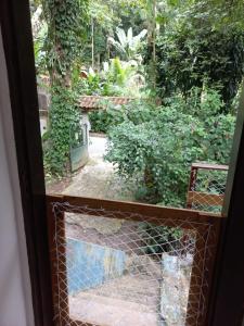 a view of a garden from a window at Loft dos Vagalumes in Boicucanga