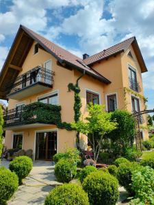 a house with a balcony and bushes at Piece of Greece in Neunburg vorm Wald