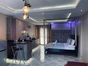 Trendy apartments في عنتيبي: غرفة نوم بسرير ومطبخ مع اضاءة ارجوانية