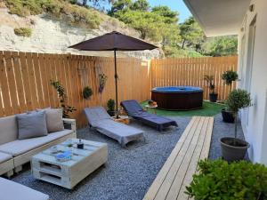 a patio with a couch and an umbrella and a pool at Elia Boutique Studios in Kalithies
