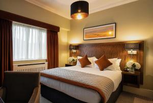 a hotel room with a bed and a window at Glenroyal Hotel in Maynooth