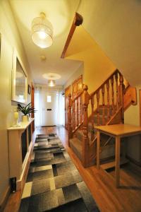 a hallway with a stairway with a wooden stair case at Fermanagh Home in Enniskillen