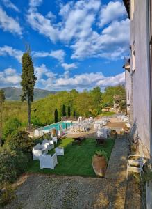 eine Außenterrasse mit einem Pool sowie Tischen und Stühlen in der Unterkunft Tenuta di Vico Moricino in Anagni