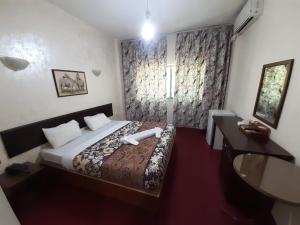 een slaapkamer met een bed, een bureau en een raam bij Amman Ambiance Hotel  in Amman +34 foto's