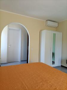 een slaapkamer met een bed met een oranje sprei bij B&B Il melograno in Capoterra