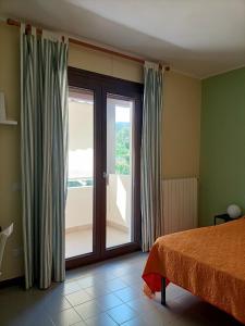 Schlafzimmer mit einem Bett und einer Glasschiebetür in der Unterkunft B&B Il melograno in Capoterra