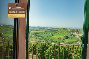 een bord op een balkon met uitzicht op een vallei bij casa di Faustina (albergo diffuso) in Corinaldo