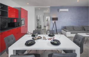 ein Wohnzimmer mit einem weißen Tisch und roten Schränken in der Unterkunft Stunning Home In Novigrad With Kitchen in Bužinija