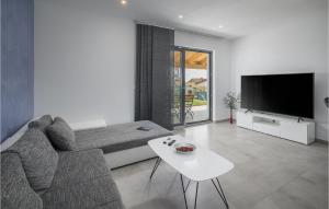ein Wohnzimmer mit einem Sofa und einem TV in der Unterkunft Stunning Home In Novigrad With Kitchen in Bužinija
