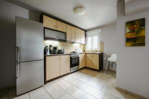 a kitchen with wooden cabinets and a refrigerator at Le Petit Jardin in Volos