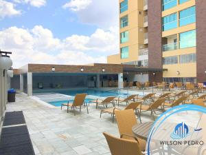 a patio with chairs and a pool in front of a building at Piazza diRoma in Caldas Novas