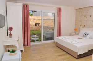 a bedroom with a bed and a large window at Allegria Butik Otel in Ildır