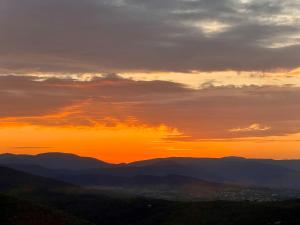 una puesta de sol en las montañas con la puesta de sol en LA GASSINIÈRE en Gassin