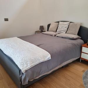 a bed in a room with a white wall at Maso Kreuzberg in Trento