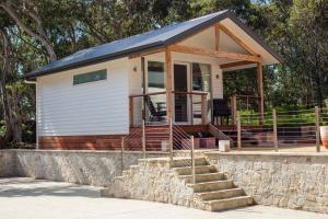 a tiny house with a roof on a stone wall at Chianti Cottages in Torquay