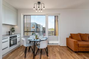 a kitchen and dining room with a table and chairs at CITYGATE APARTMENT WITH SUN BALCONY in Tartu