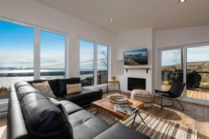 a living room with a couch and a fireplace at Le Charmant- Magnifique vue sur le fleuve et spa in Saint-Joseph-de-la-Rive