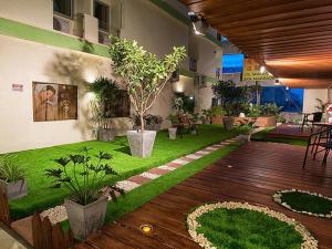 a room with a garden with plants and a wooden deck at Satit Grand View Hotel in Sadao