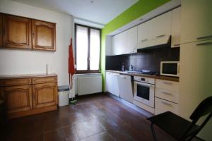 a kitchen with white and green walls and wooden cabinets at Maison de 5 chambres avec wifi a Guebwiller in Guebwiller