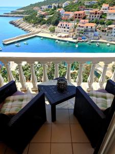 a balcony with a table and chairs and a view of the water at Apartments Laus in Zavalatica