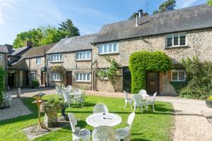 a garden with tables and chairs in front of a building at Jersey Arms Hotel Bicester in Bicester