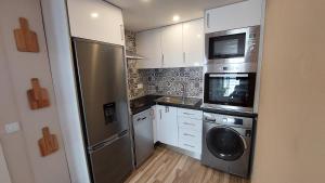 a kitchen with a stainless steel refrigerator and a dishwasher at Airport house in Faro