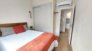 een slaapkamer met een bed met een rood kussen bij Airport house in Faro