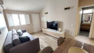 a living room with a couch and a flat screen tv at Airport house in Faro