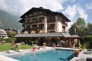 a large building with a swimming pool in front of it at Oustalet in Chamonix