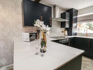 a kitchen with a bottle of champagne and two wine glasses at Bella Cottage in Kirkby Thore