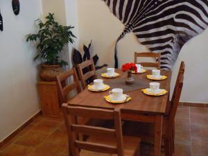 uma mesa e cadeiras de madeira com chávenas e pires em Apartmány Johanka em Náchod