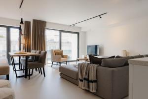a living room with a couch and a table at Portwin luxury stays in Knokke-Heist