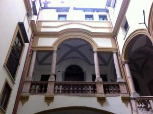 un edificio con balcón en una ciudad en Foresteria dell'Alloro, en Palermo