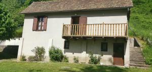Una pequeña casa con un balcón en el lateral. en maison d'hôte, gîte, la maisonnette en Vic-sur-Cère